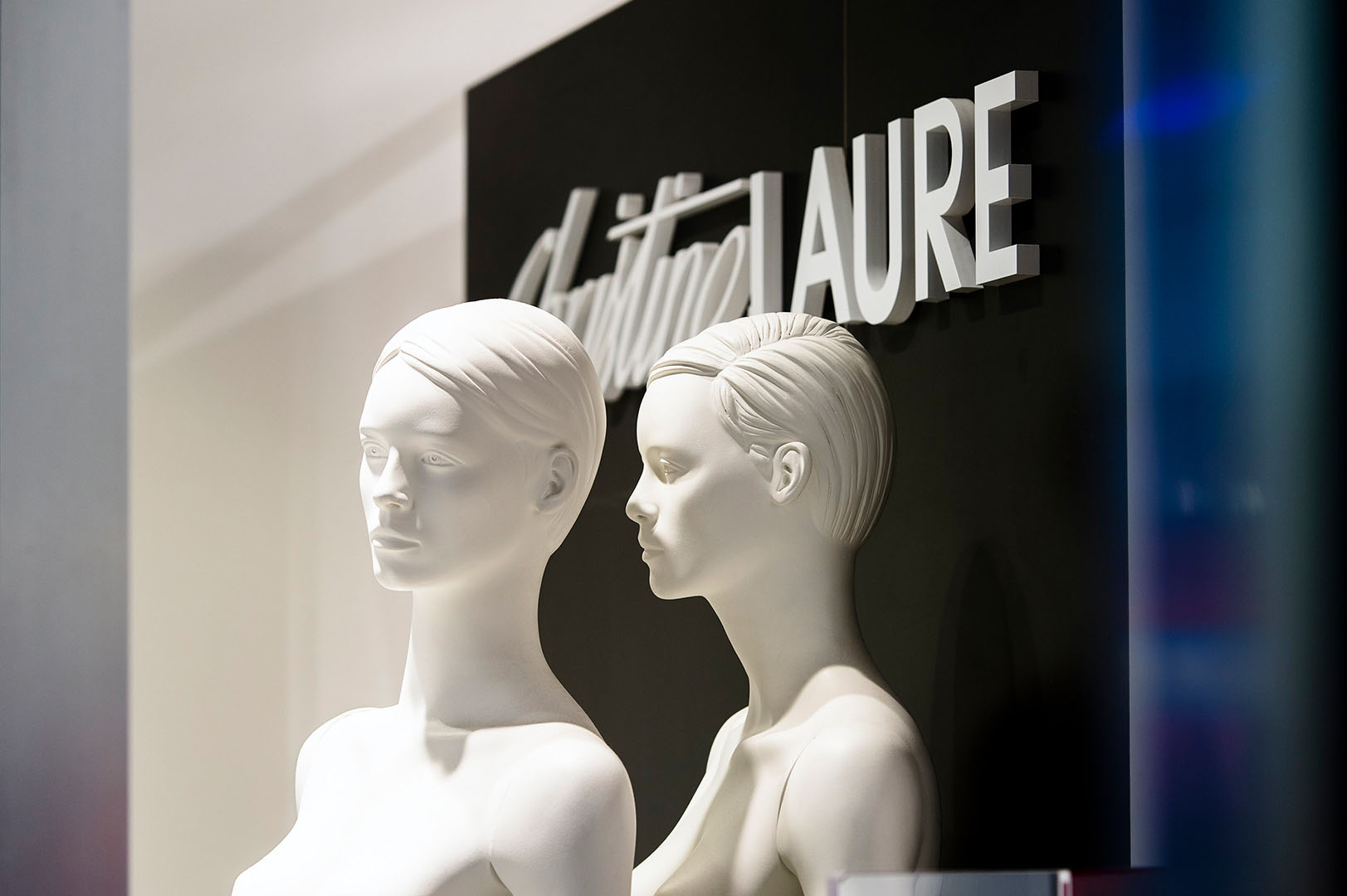 Two undressed mannequins in apparently private conversation in shop window