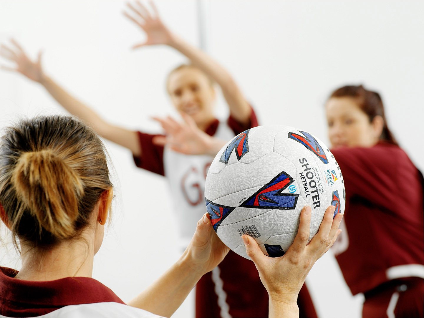 Netball player from behind looking to pass the ball