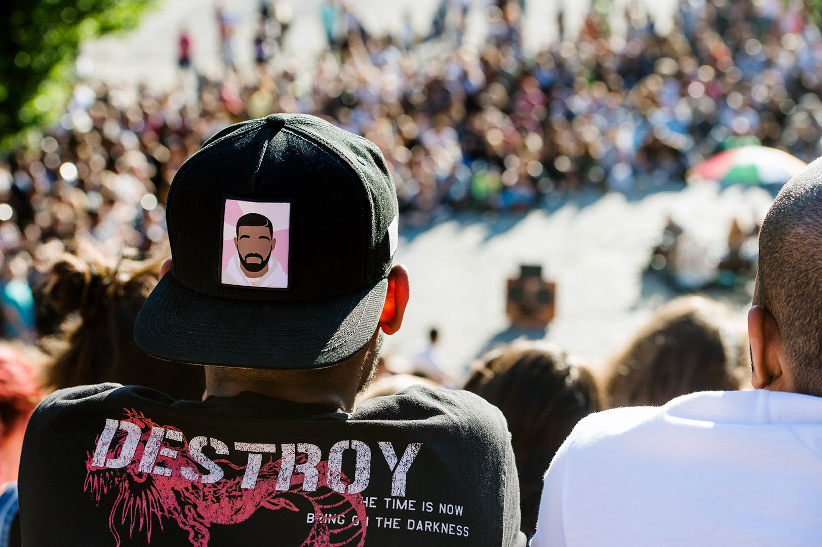 Man in Baseball cap from behind watching Bearpit Karaoke in Mauerpark Berlin