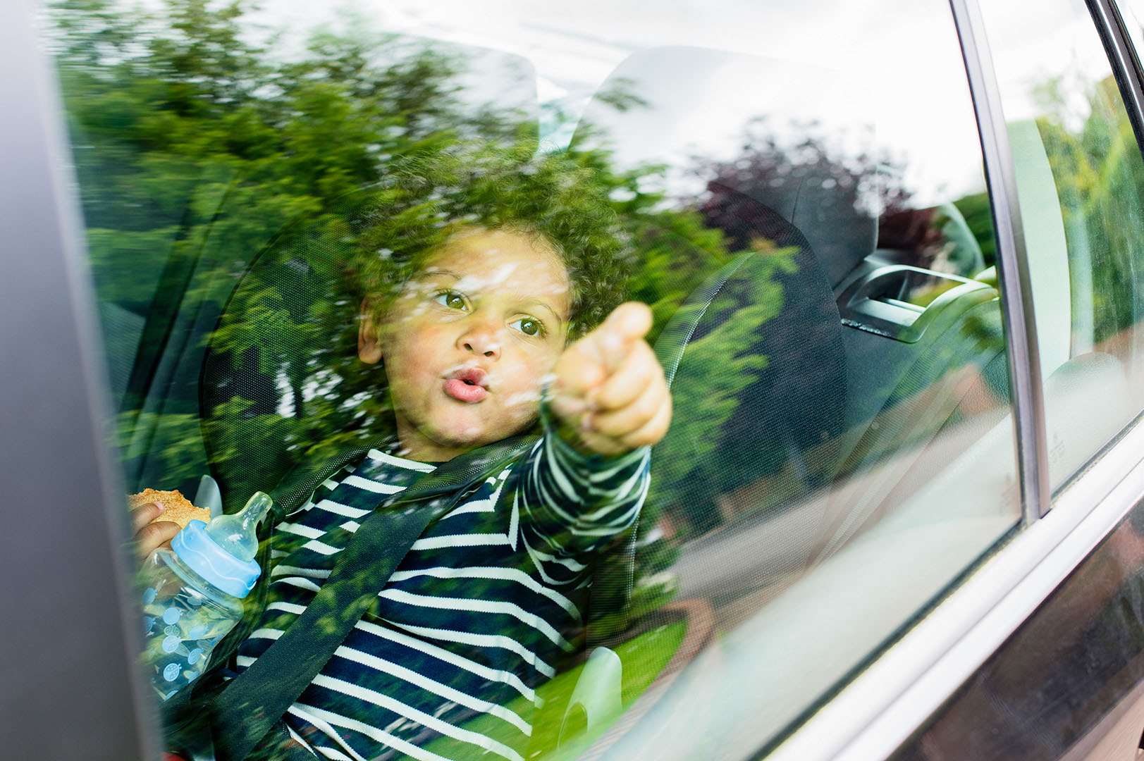 Young child in car seat looking out through car window