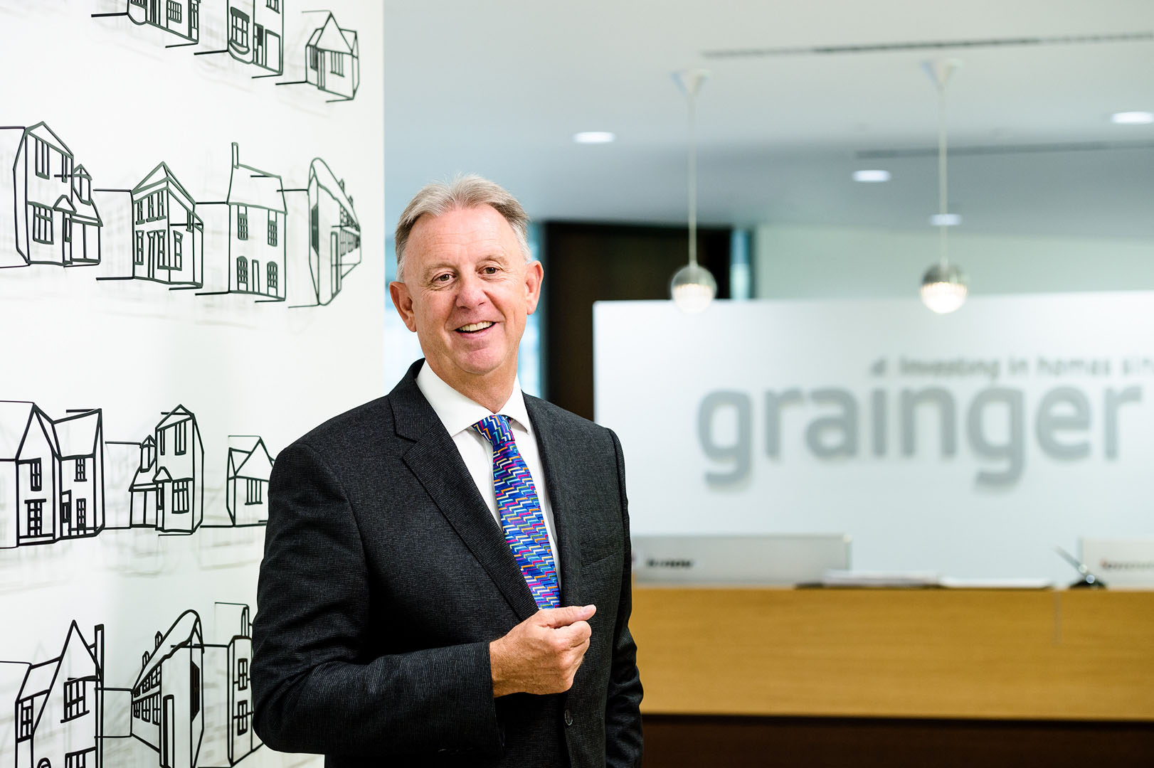 Director in animated conversation to camera in reception with branding