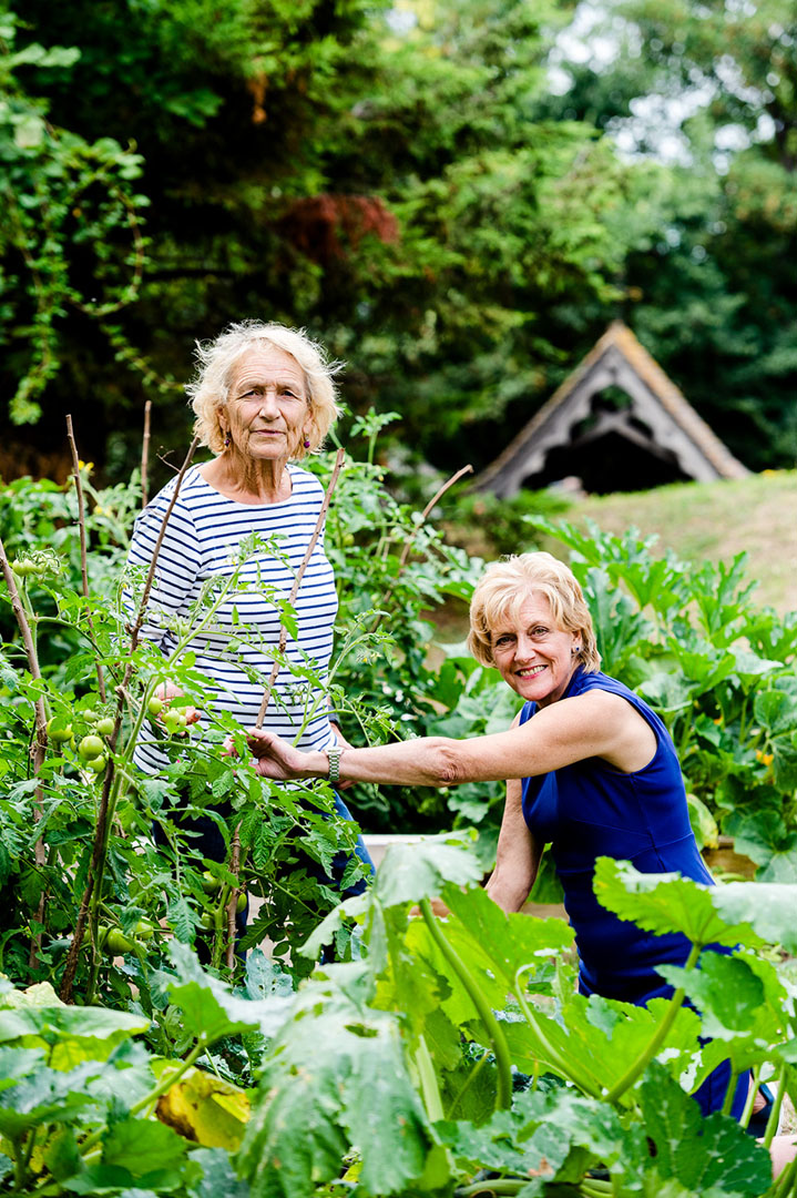 Portrait of two volunteers in a community garden