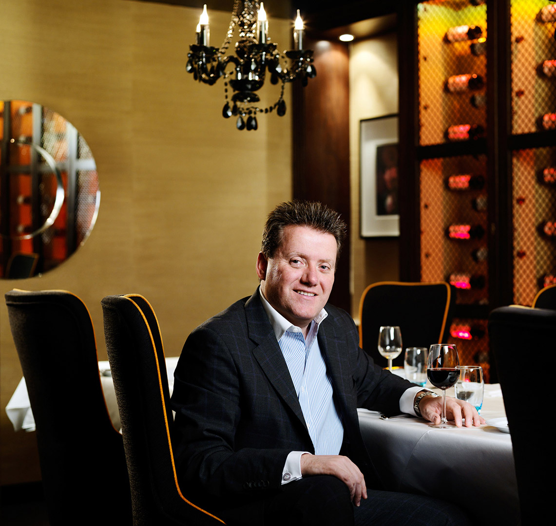 Portrait of Director seated in hospitality setting