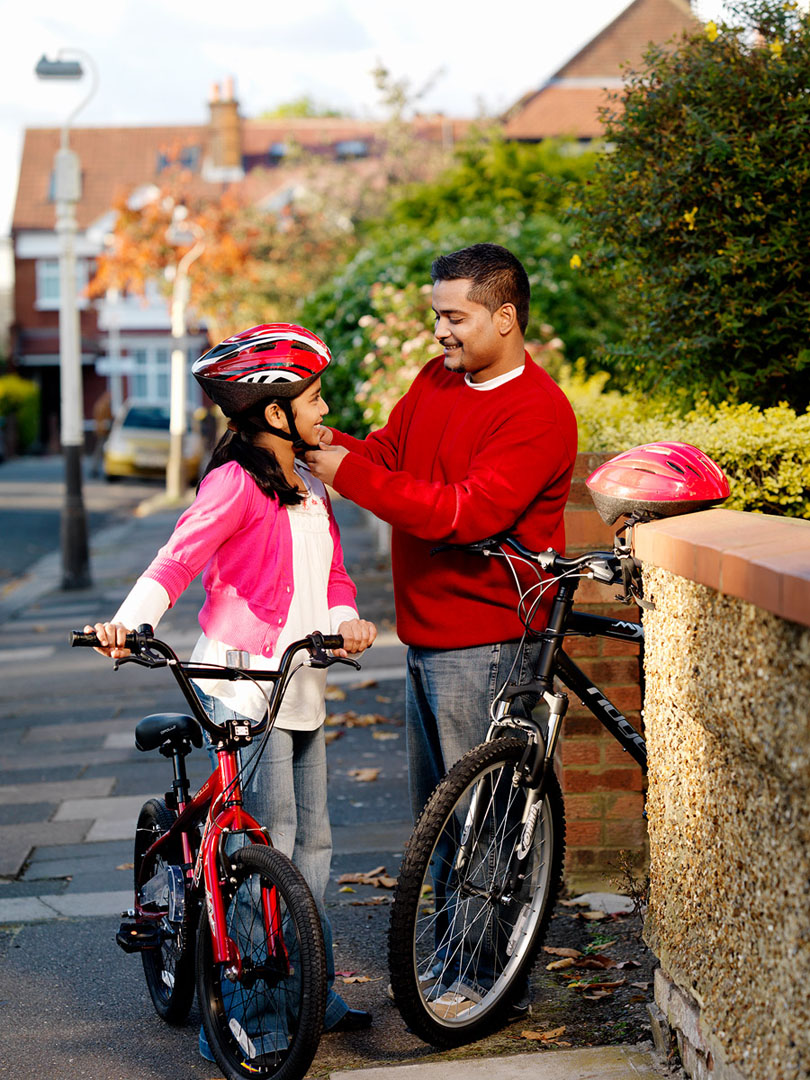 Asian father & daughter preparing for bike ride