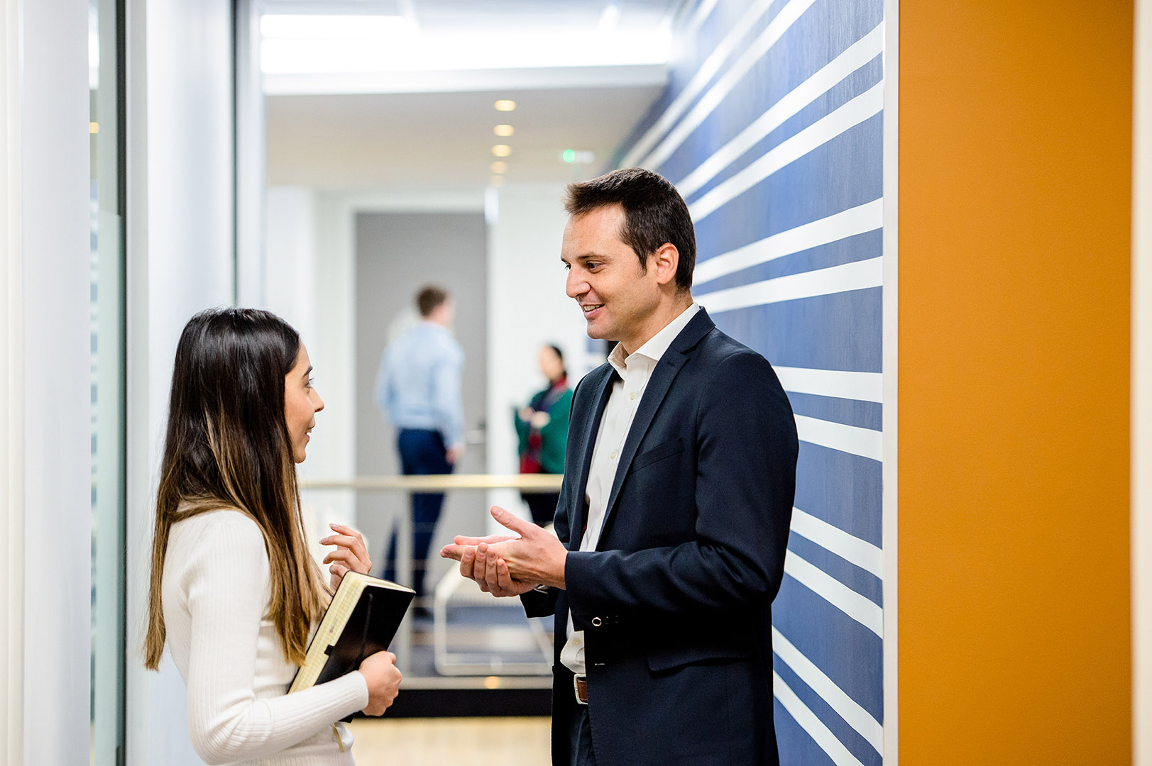 Man and woman in conversation in office corridor