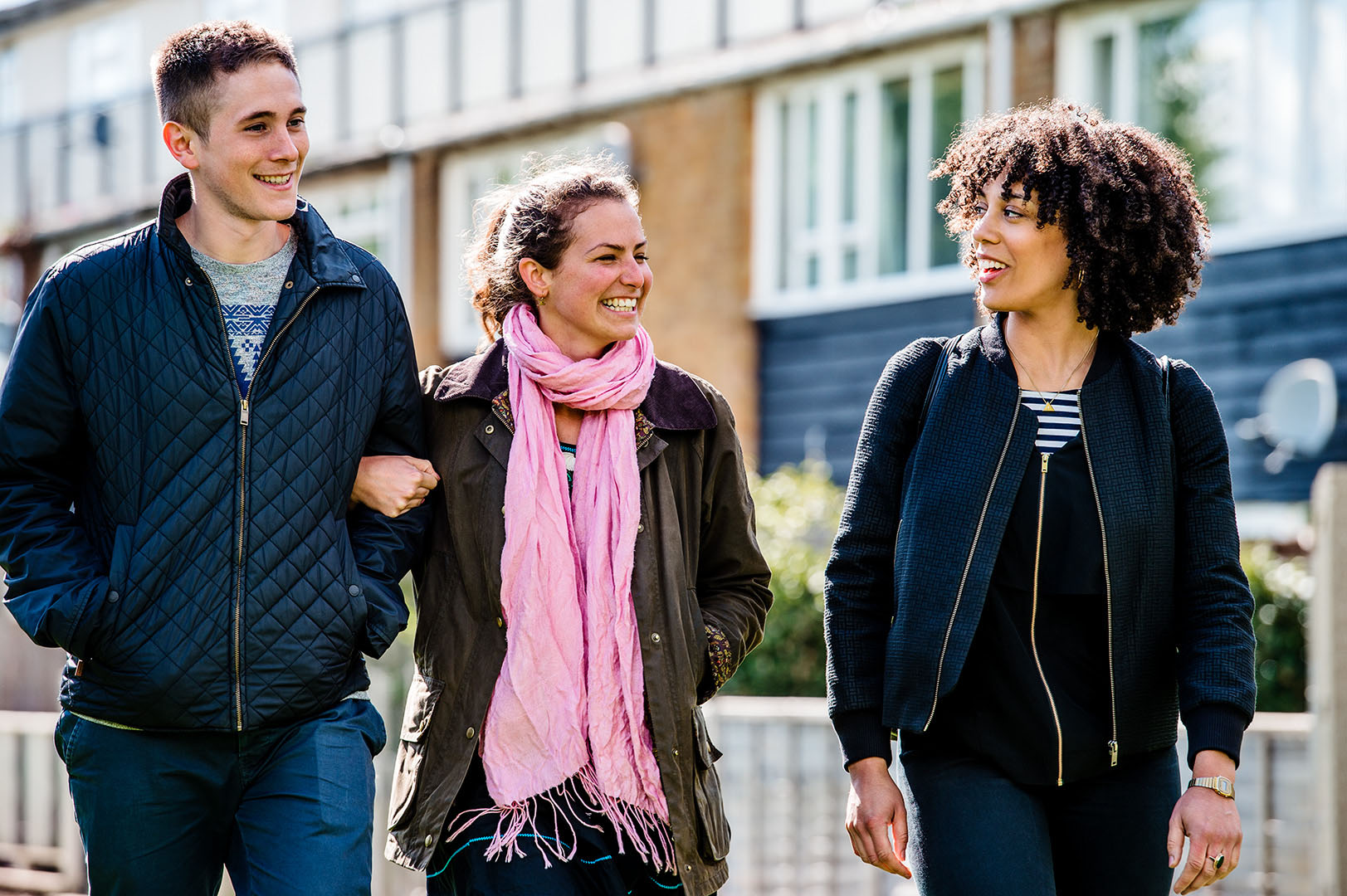 Three friends in conversation walking 