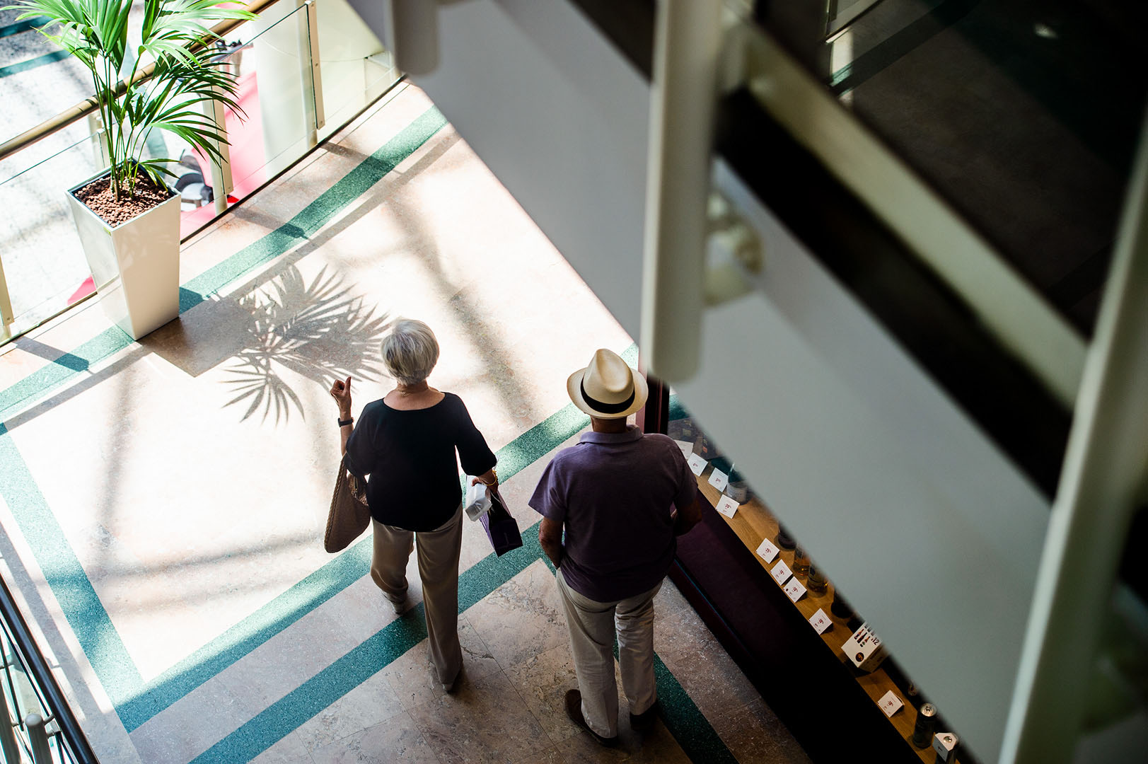 Man in trilby and woman shot from above in shopping centre