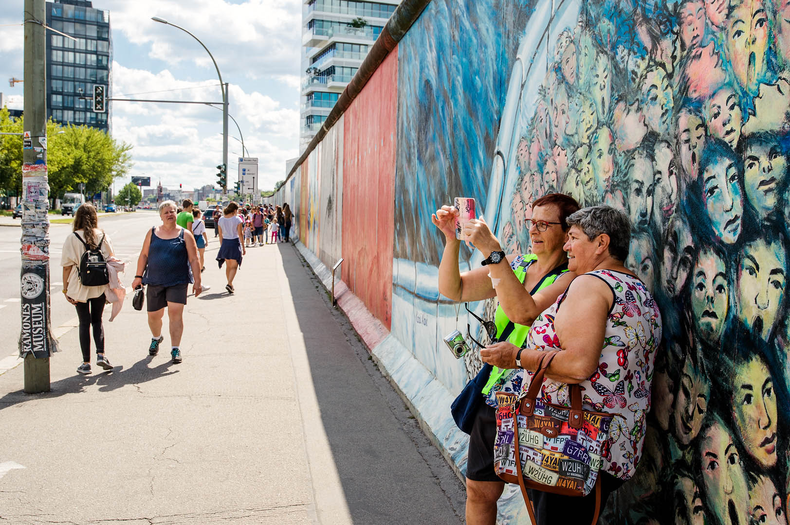 Tourists taking selfie againgst section of Berlin Wall