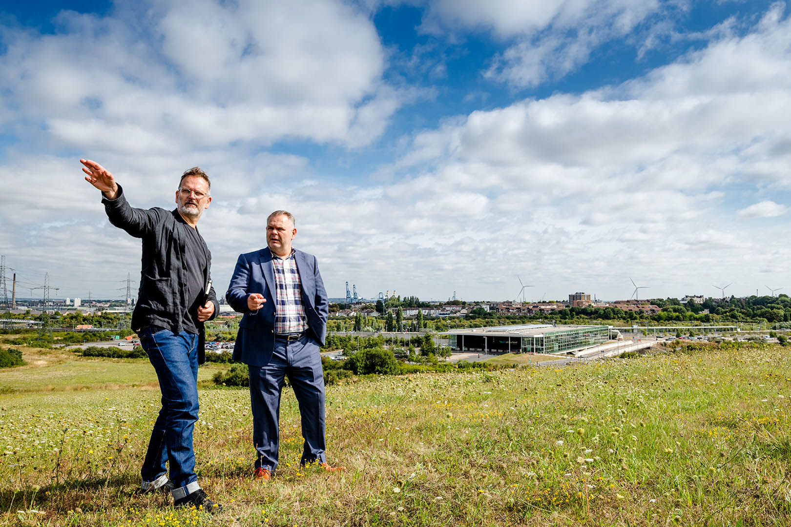 Two men looking out from elevated position over proposed development site