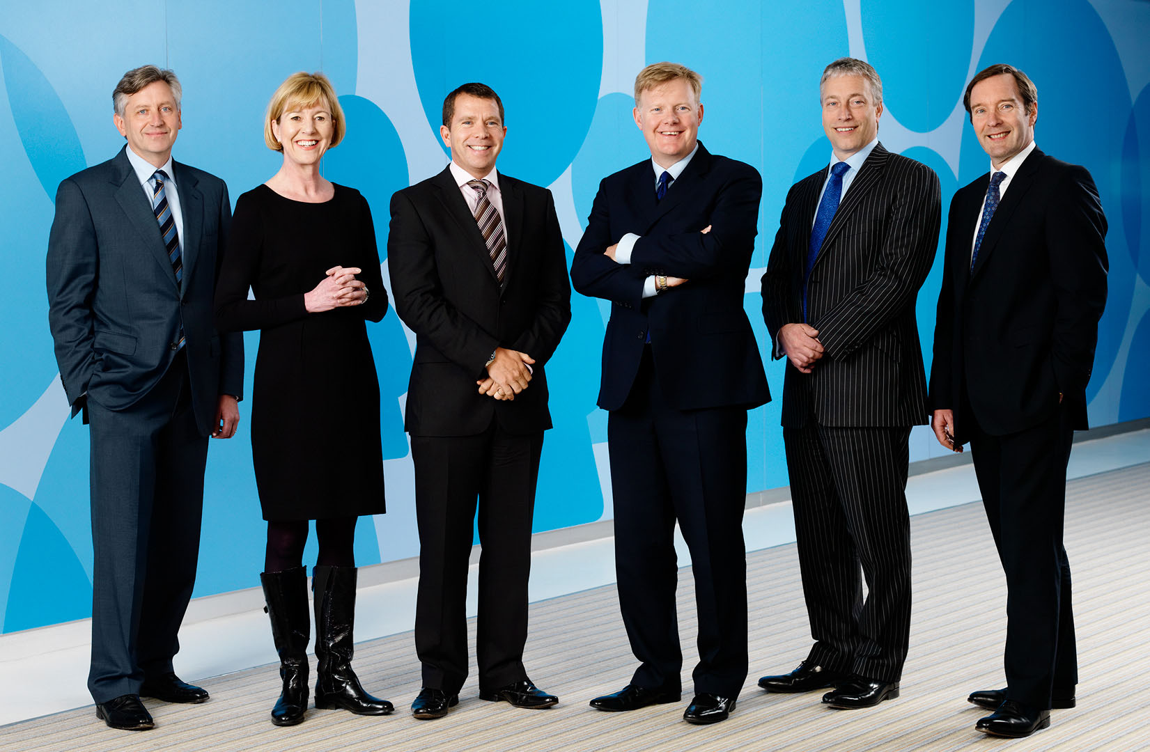 Group shot of Board of Directors with patterned blue background