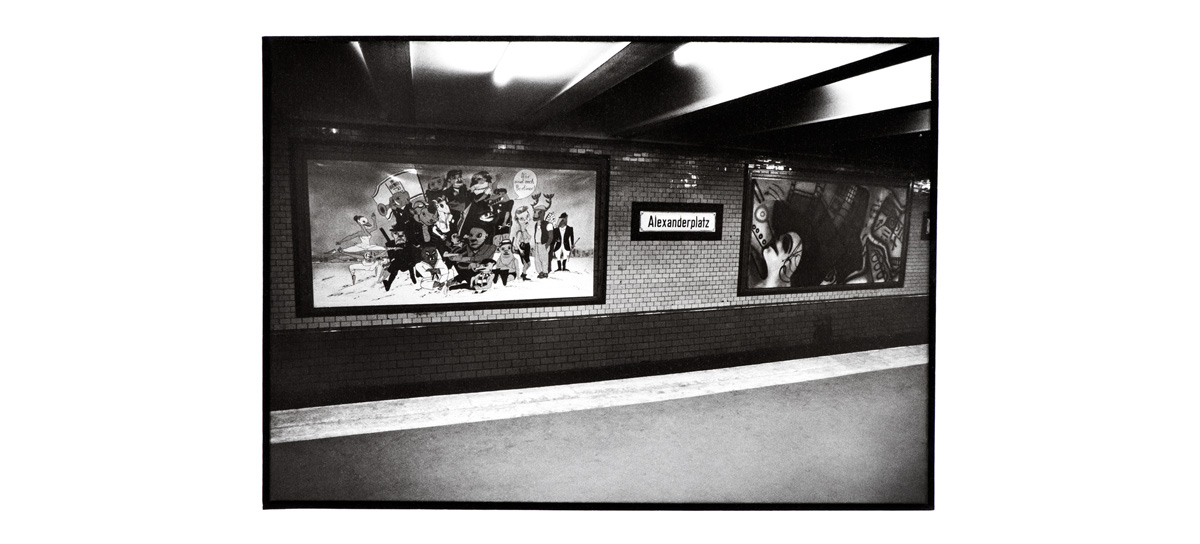 B&W shot of large paintings on the walls of Alexanderplatz metro station in 1987