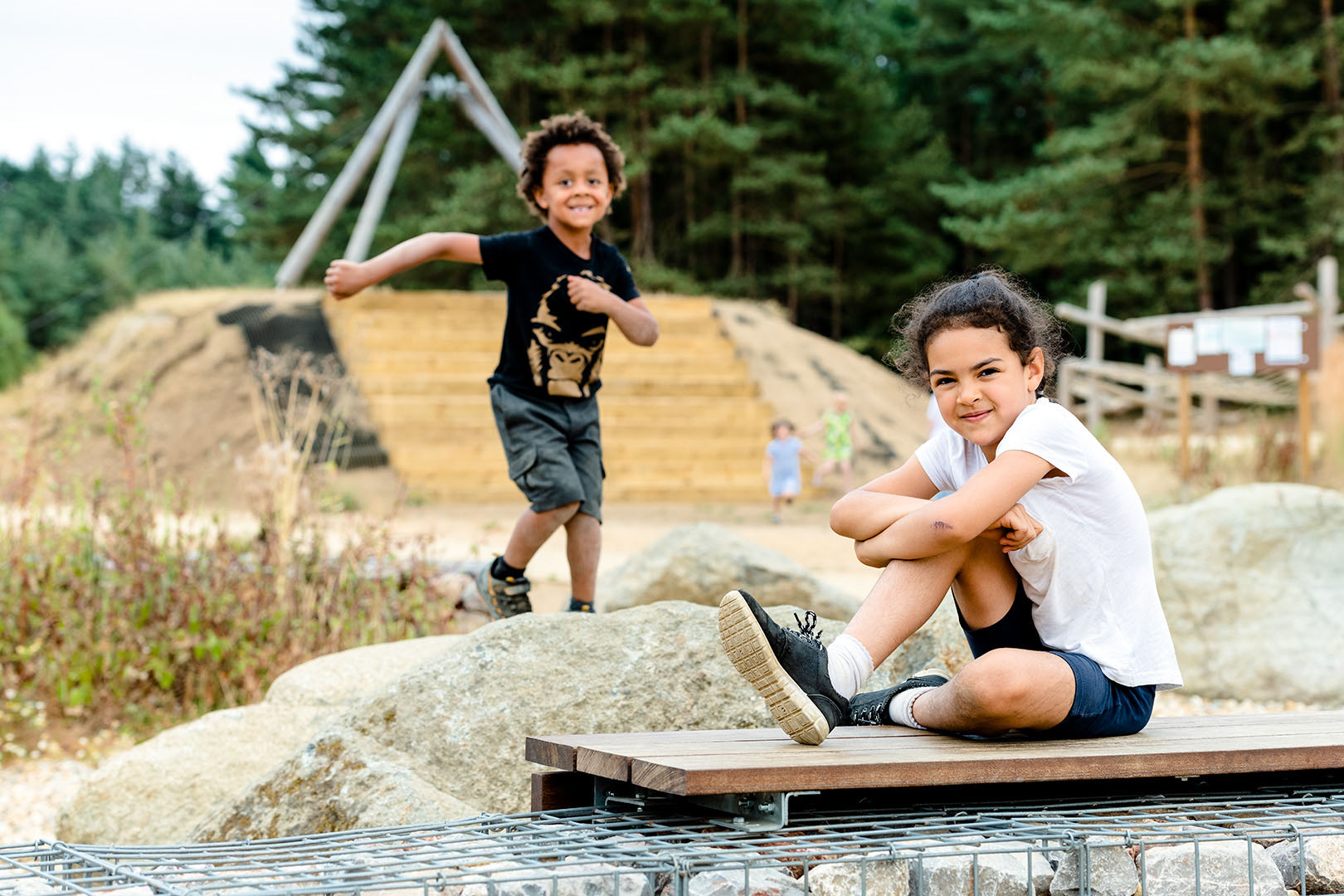 Two children looking to camera in adventure playground