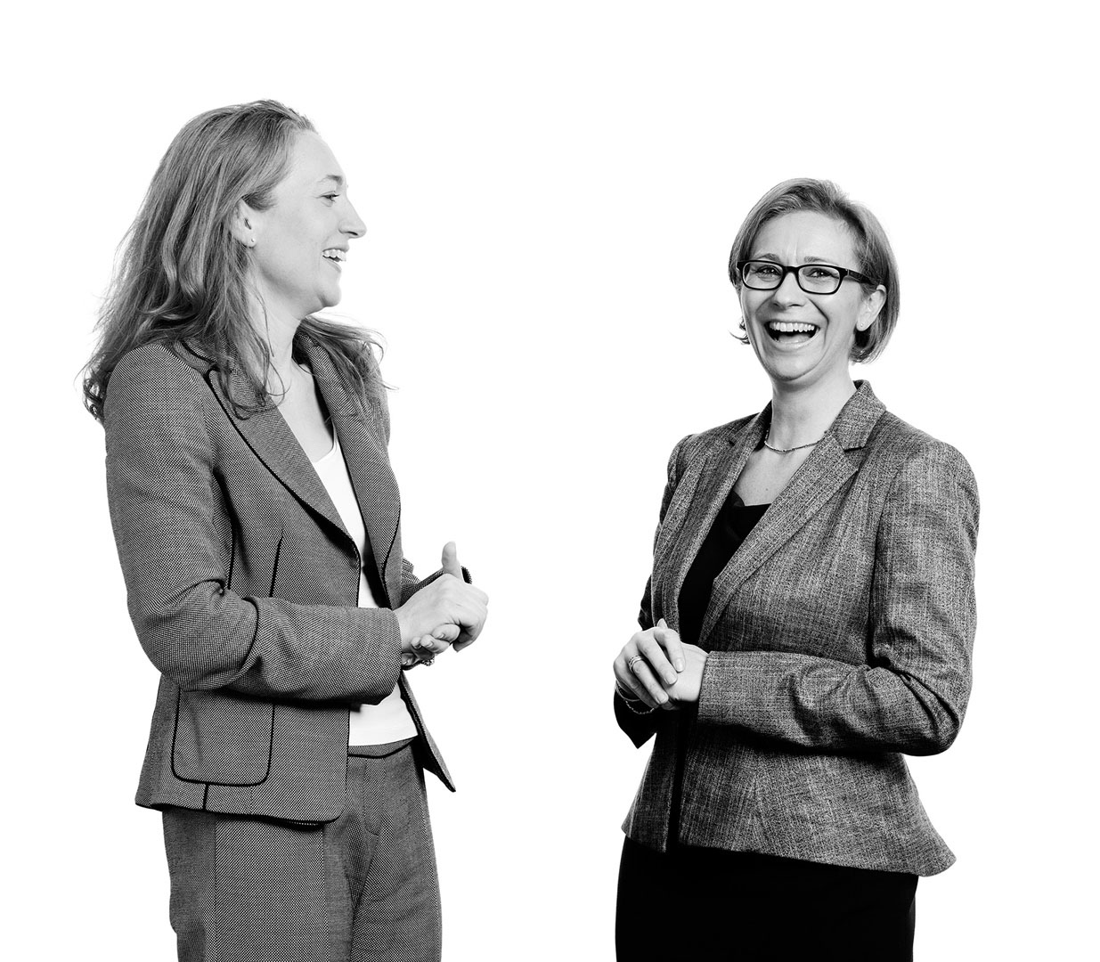 Two cut-out female business colleagues smiling in conversation