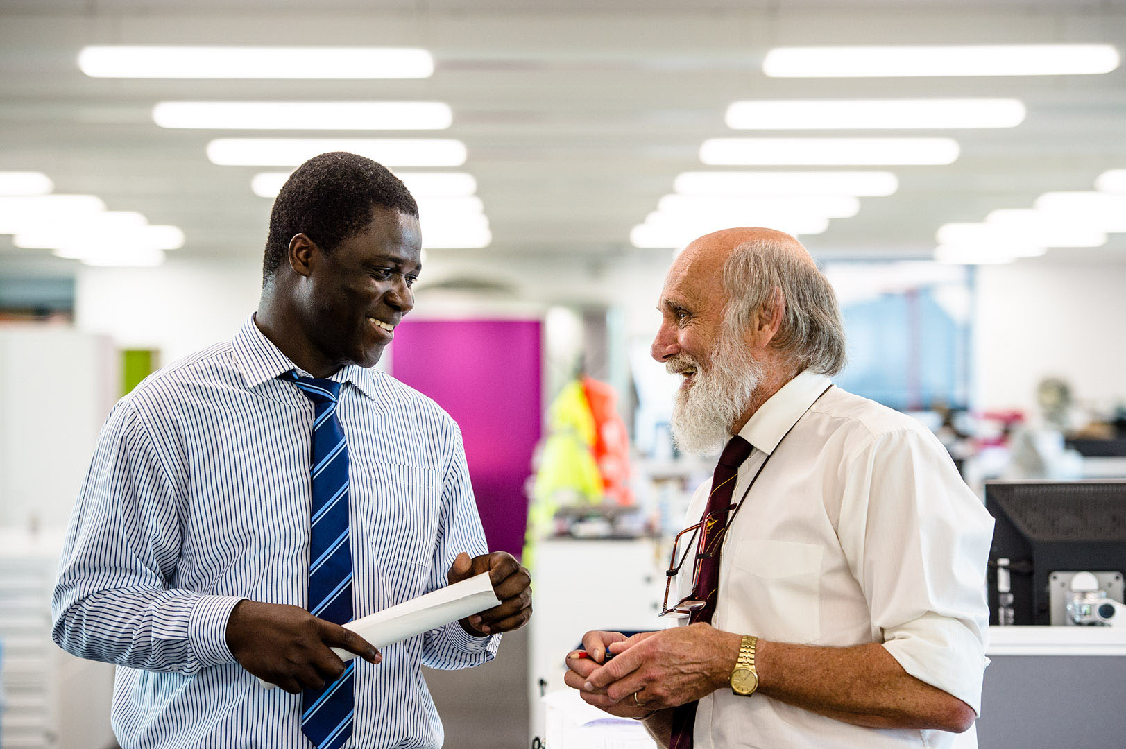 Two work colleagues in discussion in open plan office