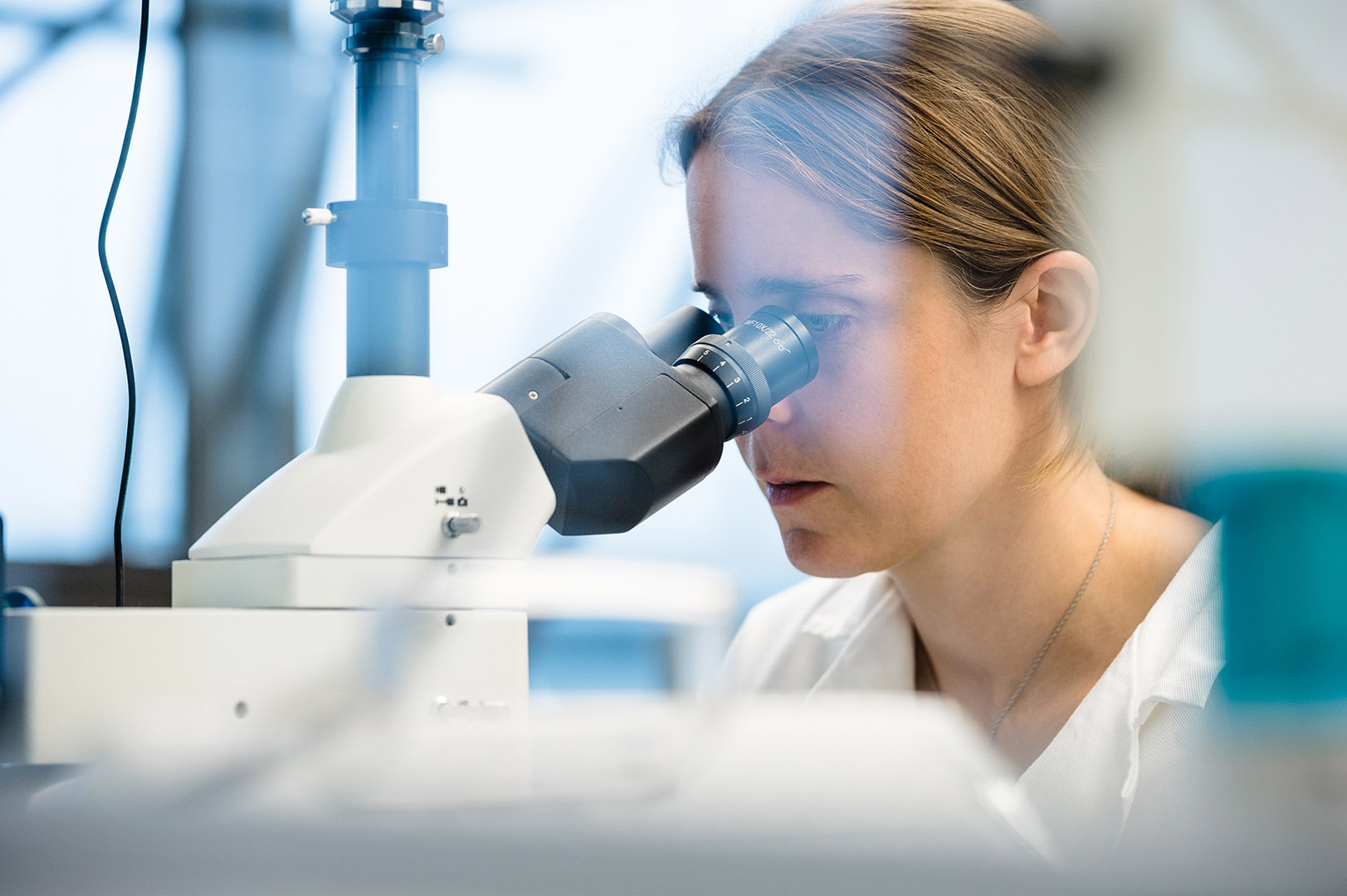 Close up of female scientist looking into microscope