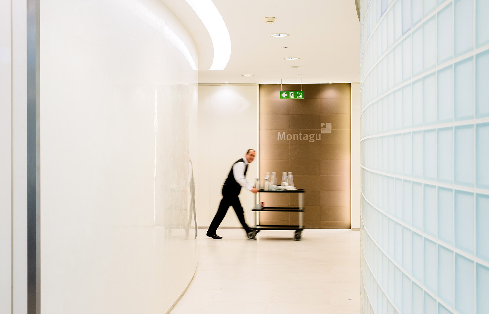 Man walking past in motion with drinks trolley in office location
