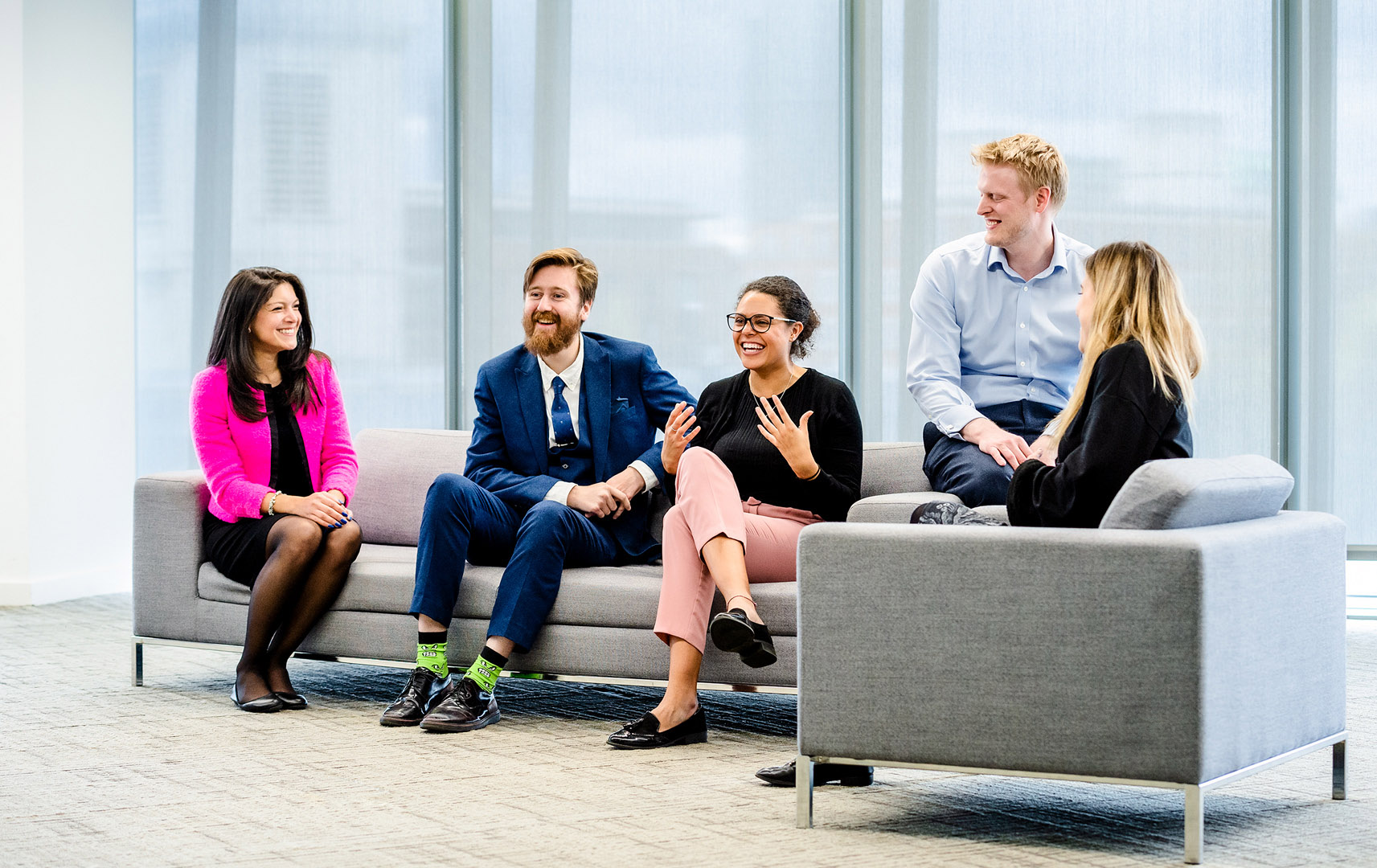 Group of five work colleagues in discussion on Sofas in Breakout area