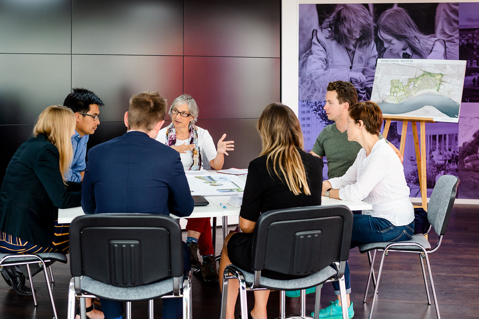 Seven people in planning meeting at developers site office