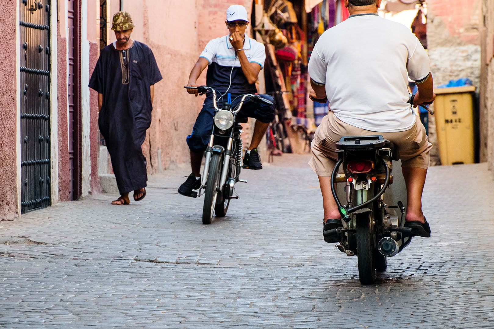 Scooters coming and going on side street in Marrakech Bazaar