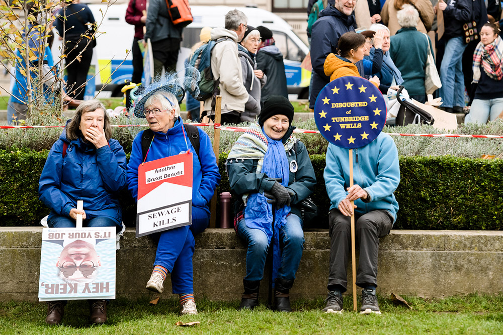 Elderly ladies sat on a wall in conversation at River Action Demo