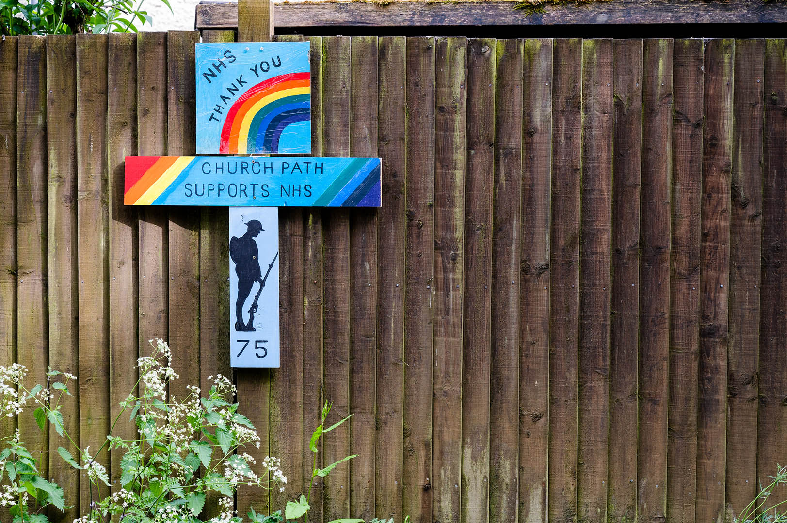Home made rainbow sign on fence supporting NHS and war heroes during lockdown 