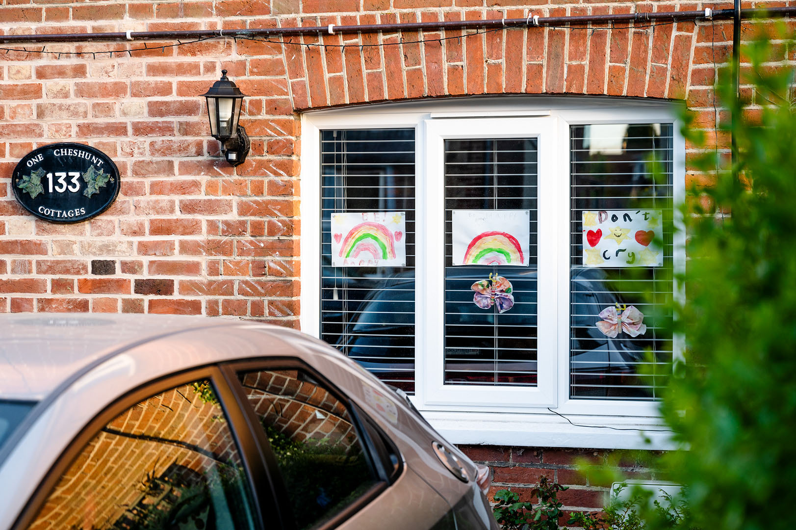 Childrens Rainbow drawings in House window during loickdown