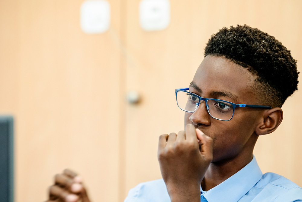 Young Black Male student in classroom engaged with computer screen